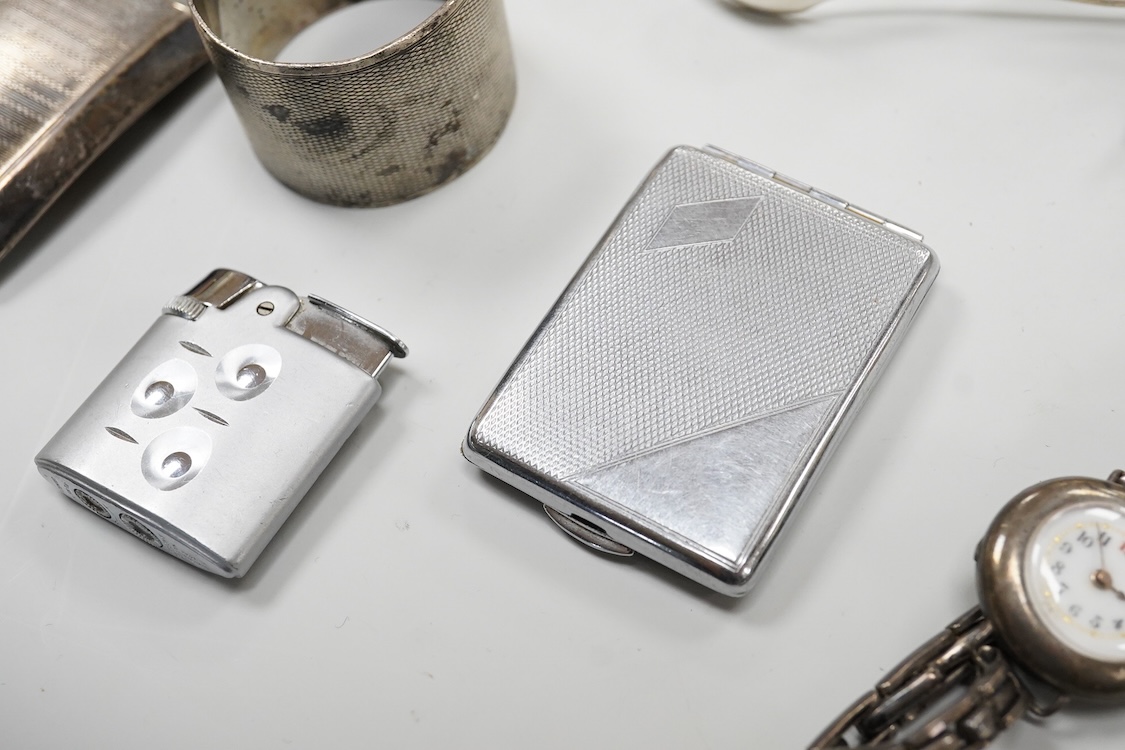 A collection of small silver to include a cigarette case, two napkin rings, three pairs of sugar tongs, a thimble, a lady's wrist watch and a mounted glass toilet jar. together with a 925 fob watch, a 935 mounted lighter